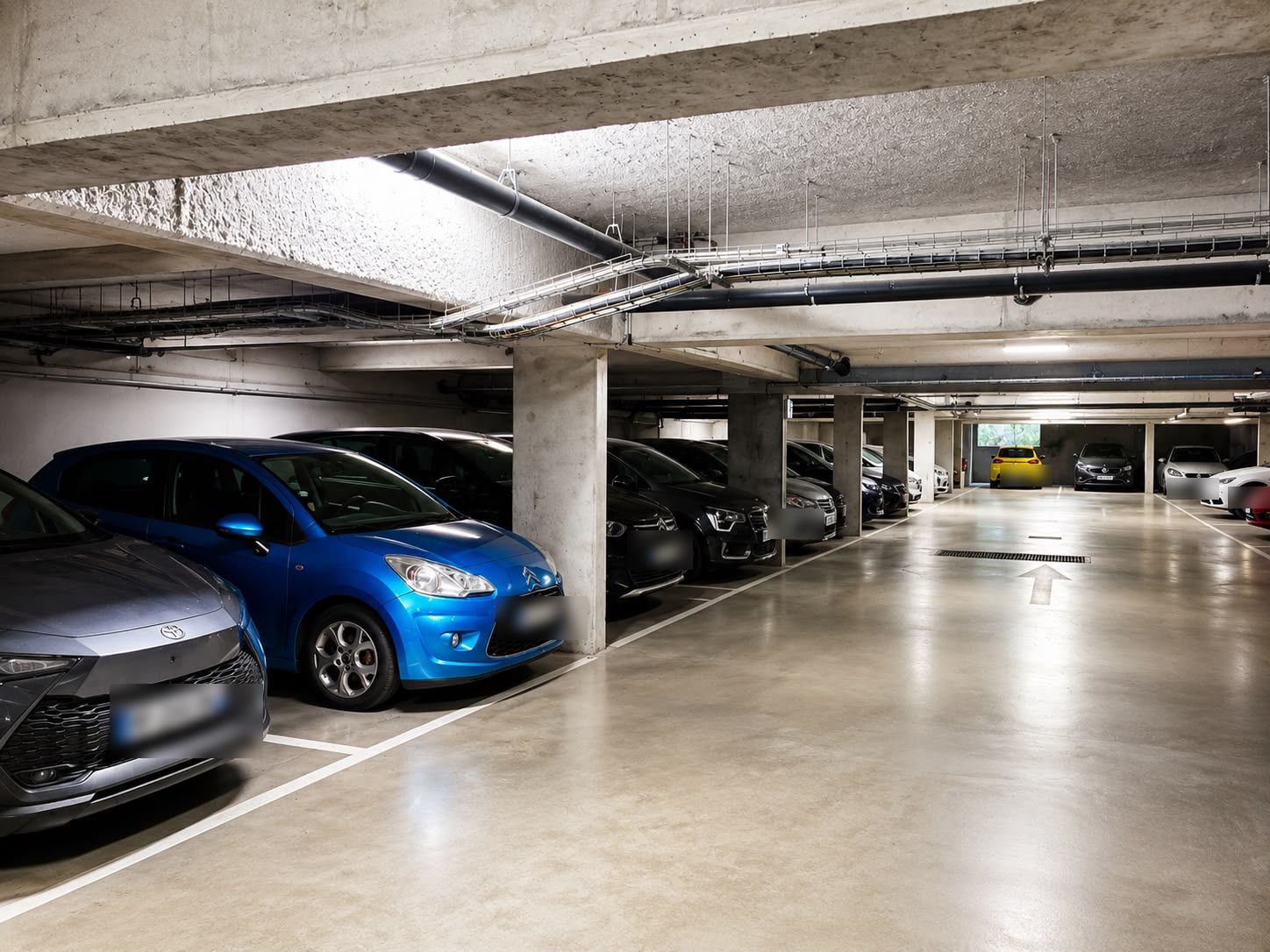 Niveau souterrain du parking Sky Valet à Paris CDG avec places individuelles marquées au sol